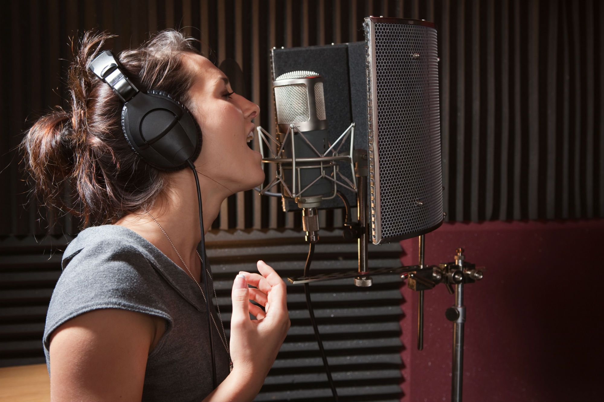 Девушка поет в студии звукозаписи